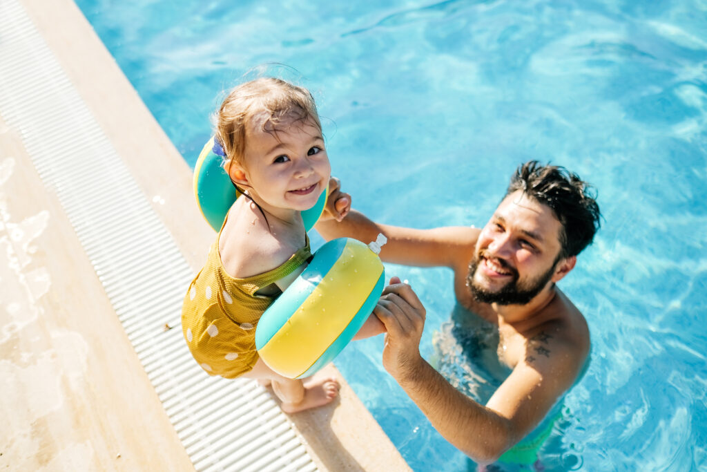 father and young daughter in pool