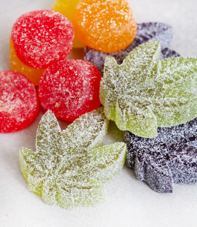 CBD and Cannabis infused jelly sweets on grey surface with copy space