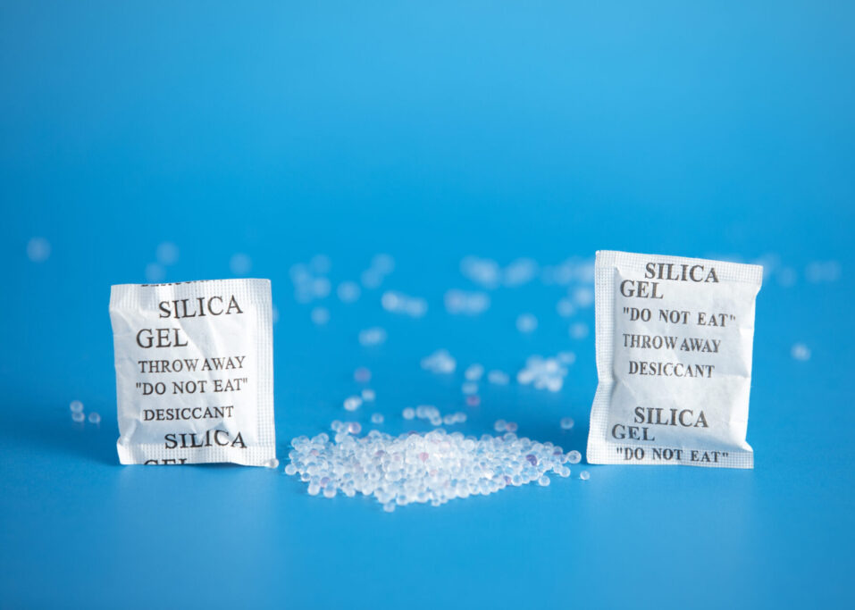 Desiccant or silica gel indifferent packaging and spread on blue background.