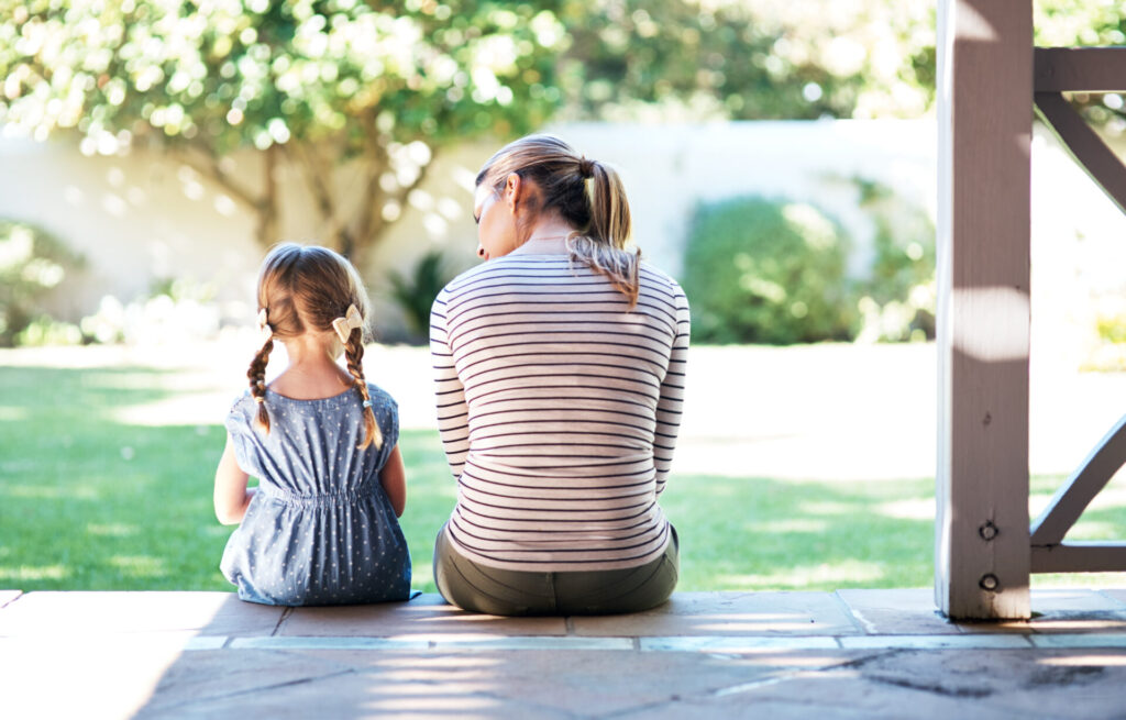 Rearview shot of a young woman and her daughter having a conversation on the porch