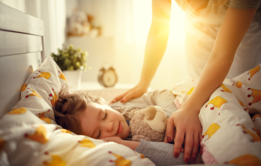 mother wakes up sleeping child daughter girl in morning