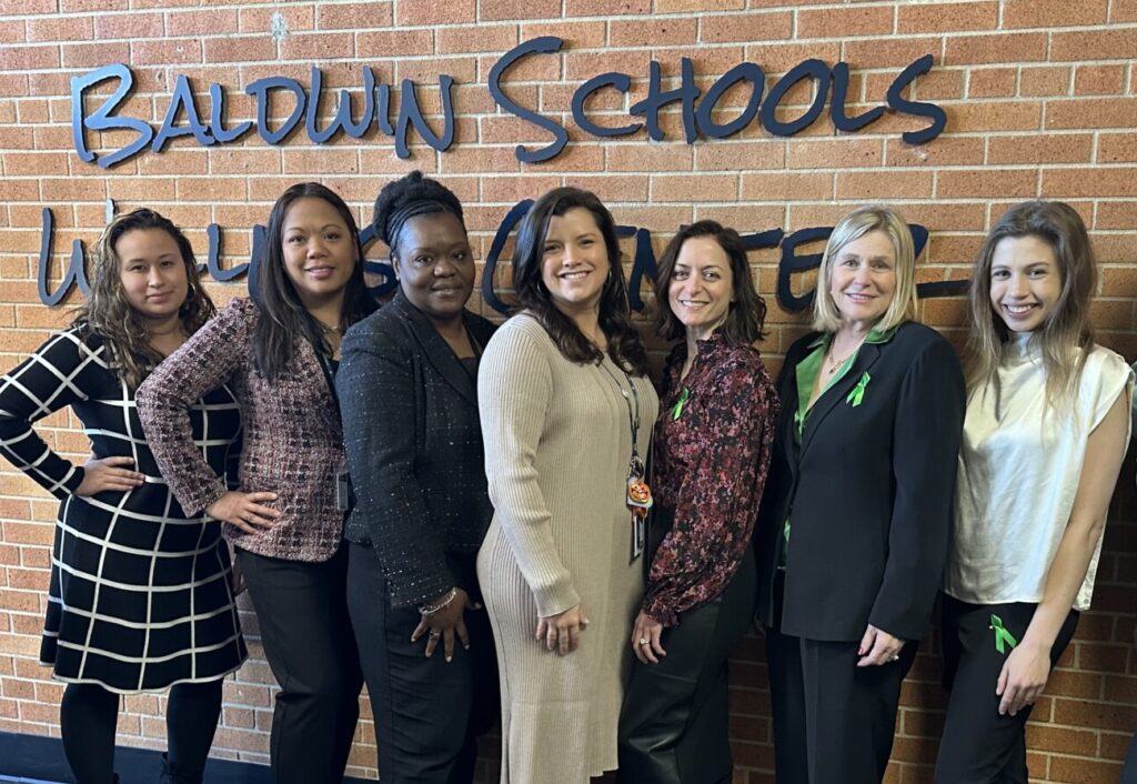 pm pediatric care team standing in front of a brick wall at the baldwin schools wellness center