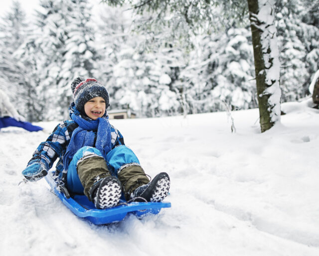 Child sledding down hill